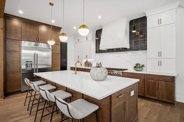 7258 Murrel Dr, Franklin, TN 37064 - kitchen featuring stainless steel built in fridge, light wood-style flooring, wall chimney range hood, and a sink