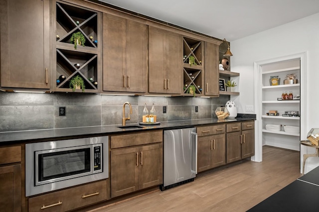 7258 Murrel Dr, Franklin, TN 37064 - bar featuring a sink, light wood-style floors, stainless steel microwave, decorative backsplash, and refrigerator