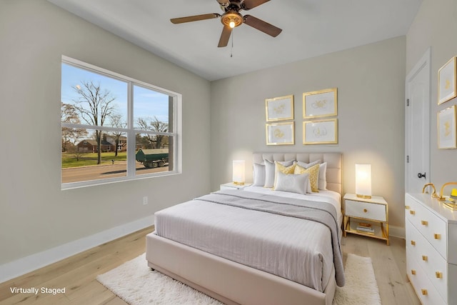 bedroom featuring baseboards, a ceiling fan, and light wood-style flooring