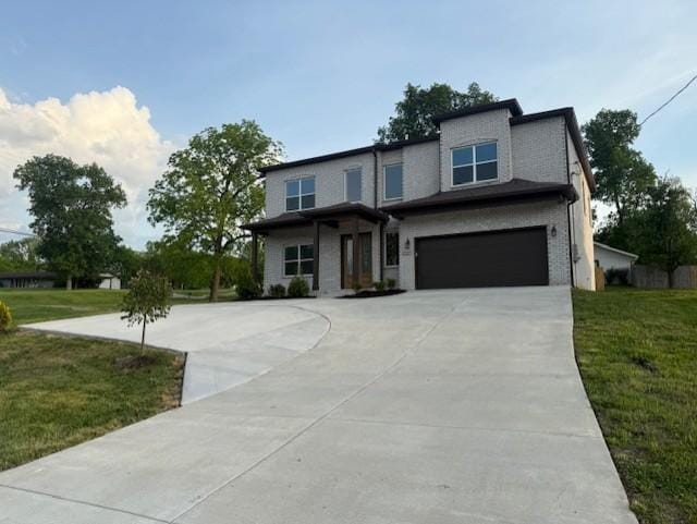 view of front facade featuring an attached garage, a front lawn, and driveway