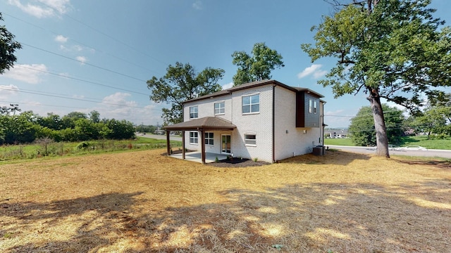 back of property featuring a patio, central AC, and brick siding