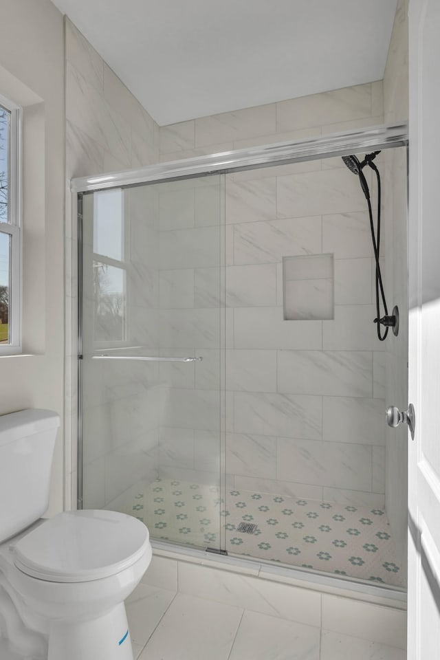 bathroom with toilet and a stall shower