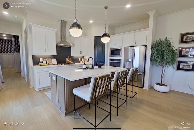 152 Salton Ln, Spring Hill, TN 37174 - kitchen with wall chimney range hood, appliances with stainless steel finishes, a sink, ornamental molding, and light wood-style flooring