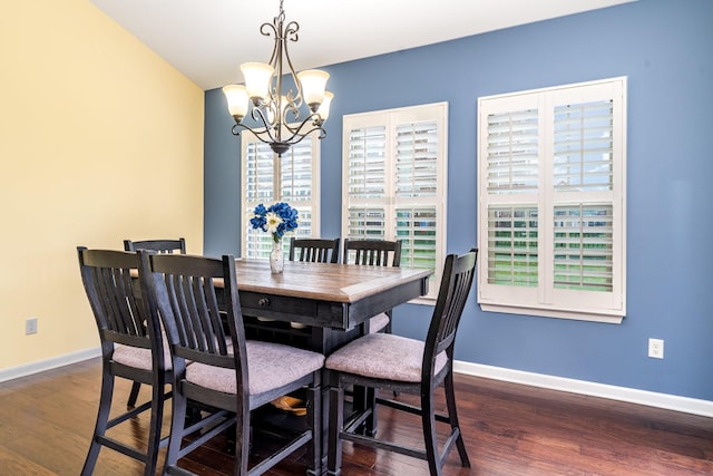 dining space with baseboards, a chandelier, and wood finished floors
