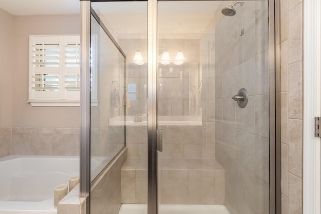 full bathroom with a shower stall and a bath
