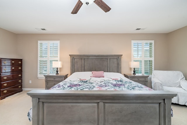 bedroom with light colored carpet, baseboards, ceiling fan, and visible vents