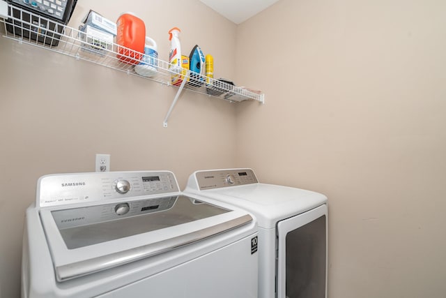clothes washing area with separate washer and dryer and laundry area