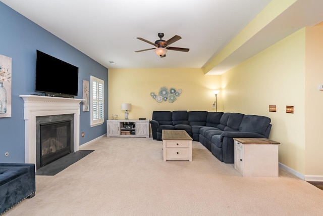 living area featuring a fireplace with flush hearth, baseboards, ceiling fan, and carpet flooring