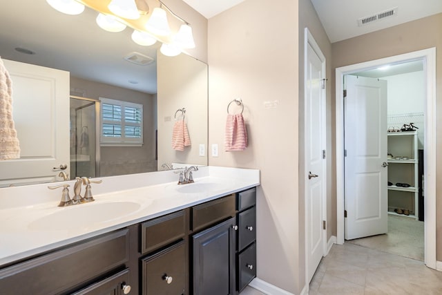 full bathroom featuring visible vents, a sink, double vanity, and a shower stall