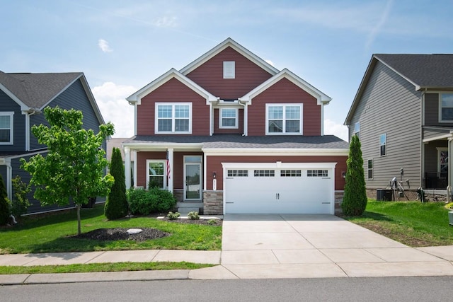 craftsman house with an attached garage, central air condition unit, a front yard, and concrete driveway