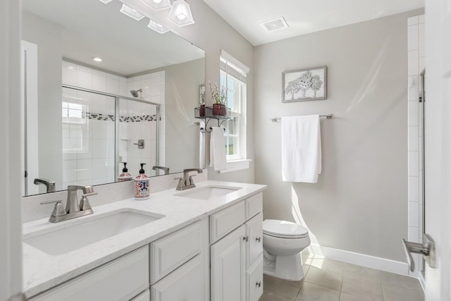 bathroom featuring a sink, tile patterned floors, toilet, and a shower stall