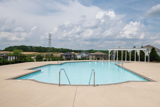 pool with a patio, fence, and a pergola