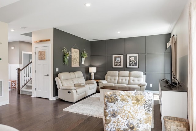 living area featuring visible vents, dark wood-style flooring, a decorative wall, stairway, and recessed lighting