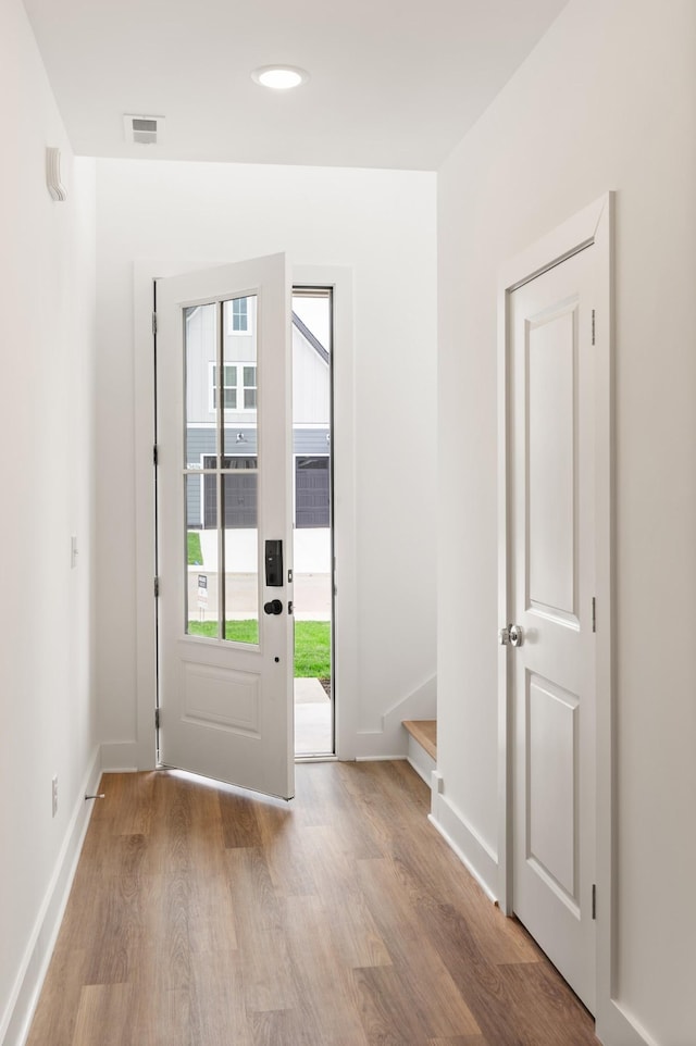 entryway featuring baseboards, visible vents, and light wood finished floors