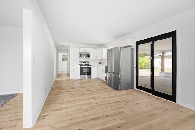 interior space featuring baseboards and light wood finished floors