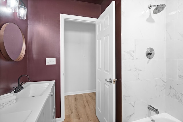 full bath with vanity, baseboards, wood finished floors, and bathing tub / shower combination