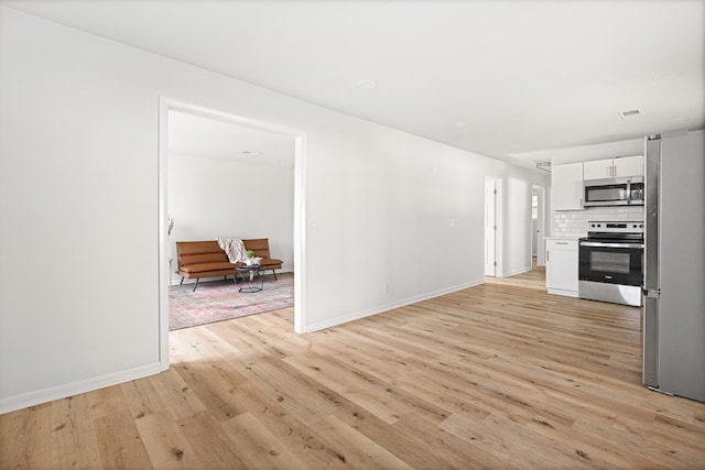 unfurnished living room featuring light wood-style floors and baseboards