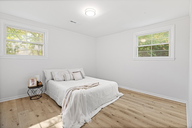 bedroom featuring baseboards, visible vents, and light wood-type flooring