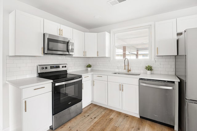 kitchen with light countertops, a sink, white cabinetry, and stainless steel appliances