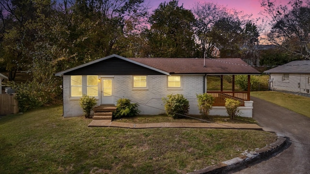 single story home featuring a yard and brick siding