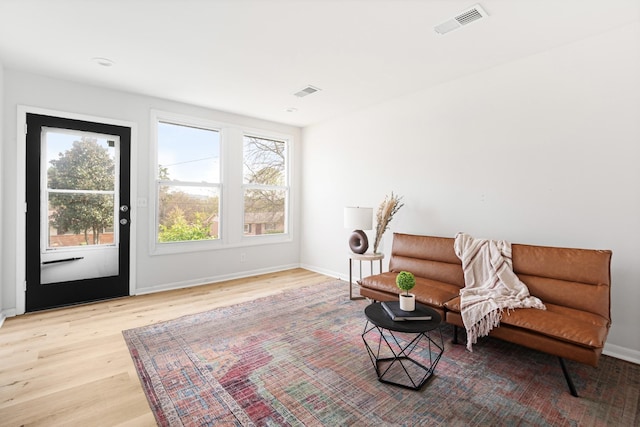sitting room with light wood-style floors, baseboards, and visible vents