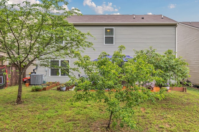view of property exterior featuring fence, a yard, a garden, and cooling unit