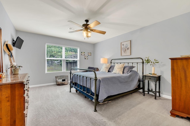 bedroom featuring baseboards, a ceiling fan, visible vents, and light carpet