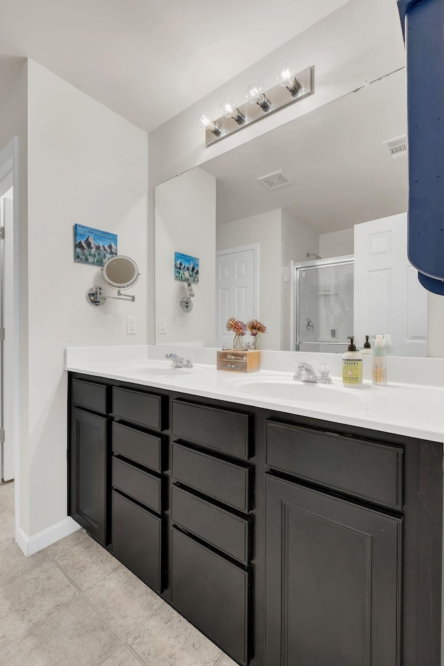 full bath featuring double vanity, visible vents, and a shower stall