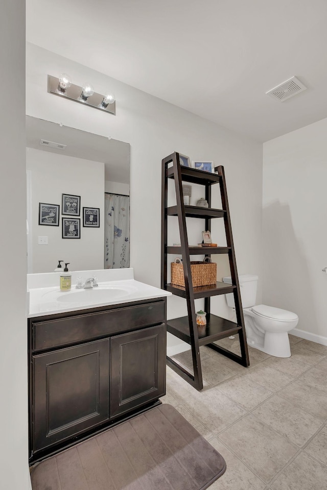 bathroom with visible vents, baseboards, toilet, and vanity