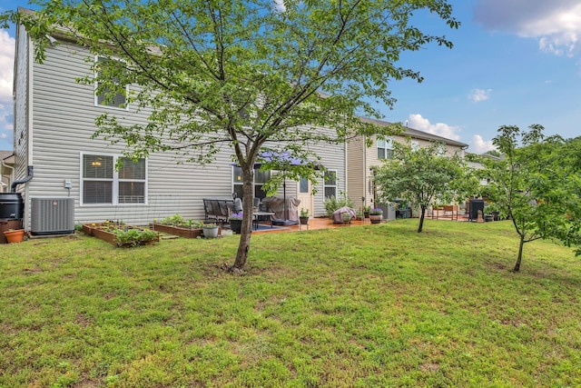 back of house with a lawn, a garden, and cooling unit
