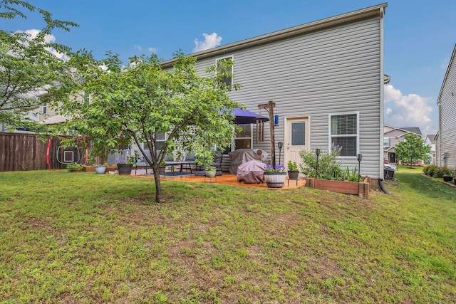 back of house featuring a lawn, a patio area, and fence