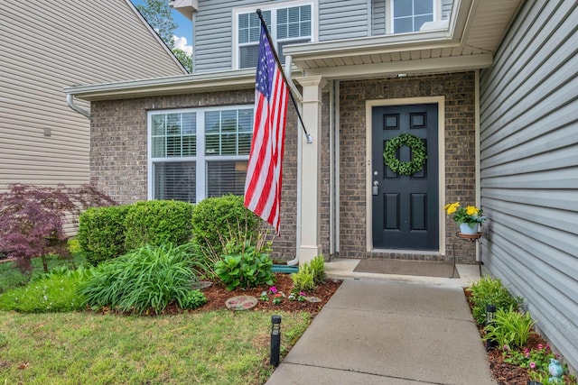 view of exterior entry featuring brick siding