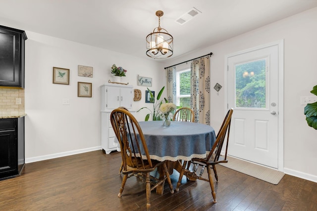 dining area featuring visible vents, dark wood-style flooring, baseboards, and a chandelier