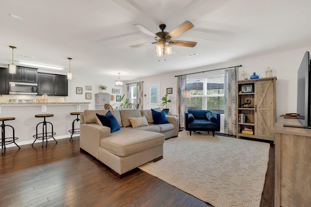 living area featuring a ceiling fan, wood finished floors, and visible vents
