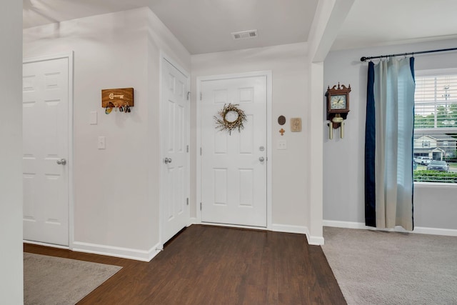 foyer entrance with baseboards, dark wood-style floors, and visible vents