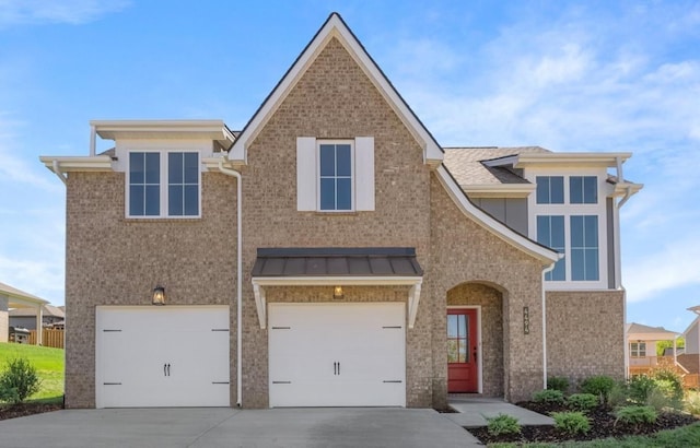 view of front of house with brick siding, a garage, and driveway