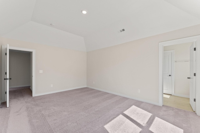 unfurnished room featuring visible vents, baseboards, lofted ceiling, light carpet, and recessed lighting