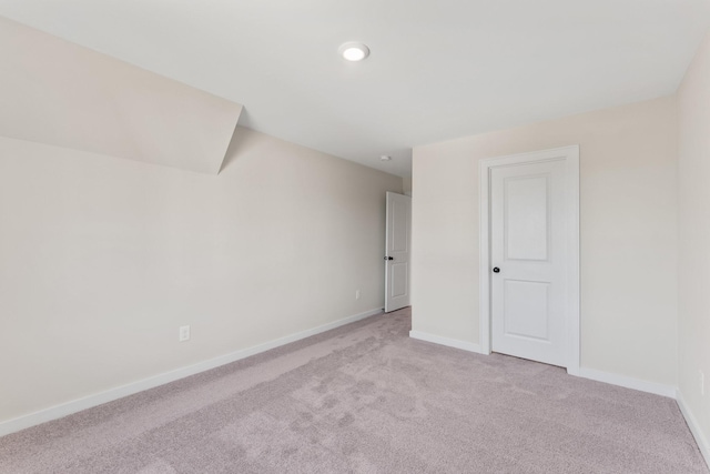 unfurnished room with baseboards and light carpet