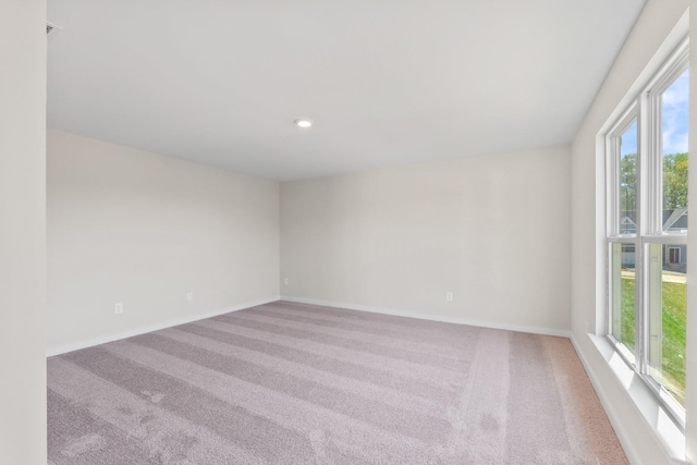 carpeted empty room featuring baseboards, plenty of natural light, and recessed lighting