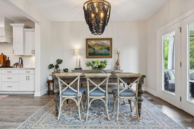 dining area with an inviting chandelier, baseboards, and wood finished floors