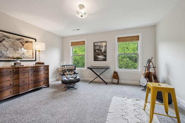 living area with visible vents, baseboards, carpet floors, and a healthy amount of sunlight