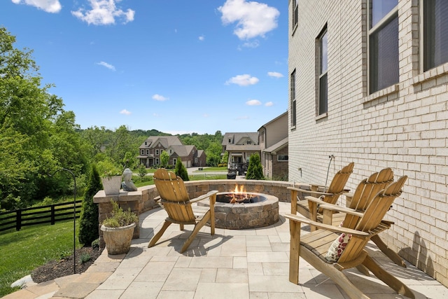 view of patio with a fire pit, fence, and a residential view