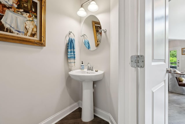 bathroom with baseboards and wood finished floors