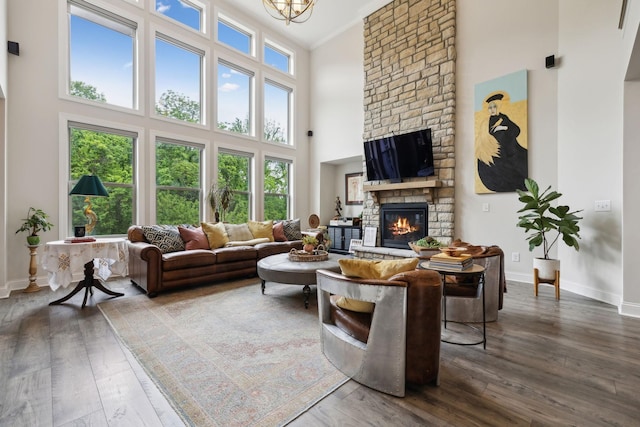 living room featuring baseboards, a fireplace, dark wood-type flooring, and a towering ceiling