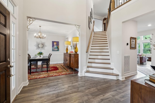 entrance foyer featuring visible vents, dark wood-style flooring, baseboards, stairway, and a notable chandelier