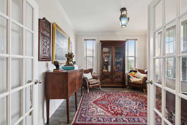 sitting room with dark wood finished floors, ornamental molding, and french doors