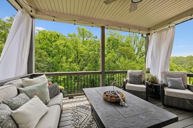 sunroom / solarium featuring an outdoor living space with a fire pit and ceiling fan