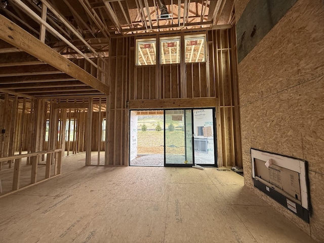 unfurnished living room featuring a towering ceiling