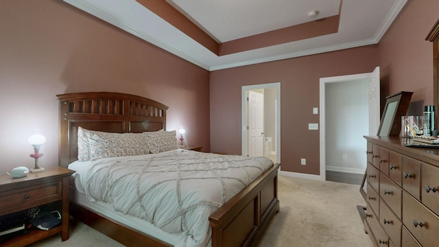 bedroom featuring a tray ceiling, light carpet, ensuite bath, and baseboards