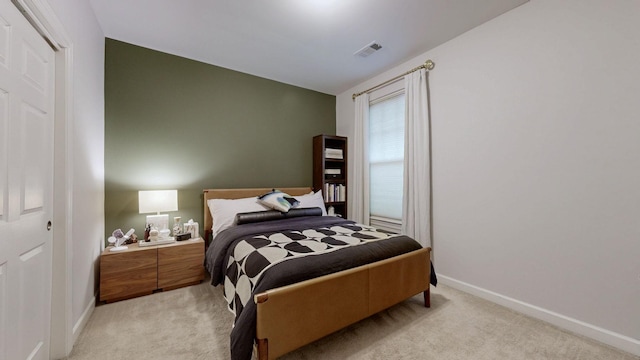 bedroom featuring light colored carpet, visible vents, and baseboards